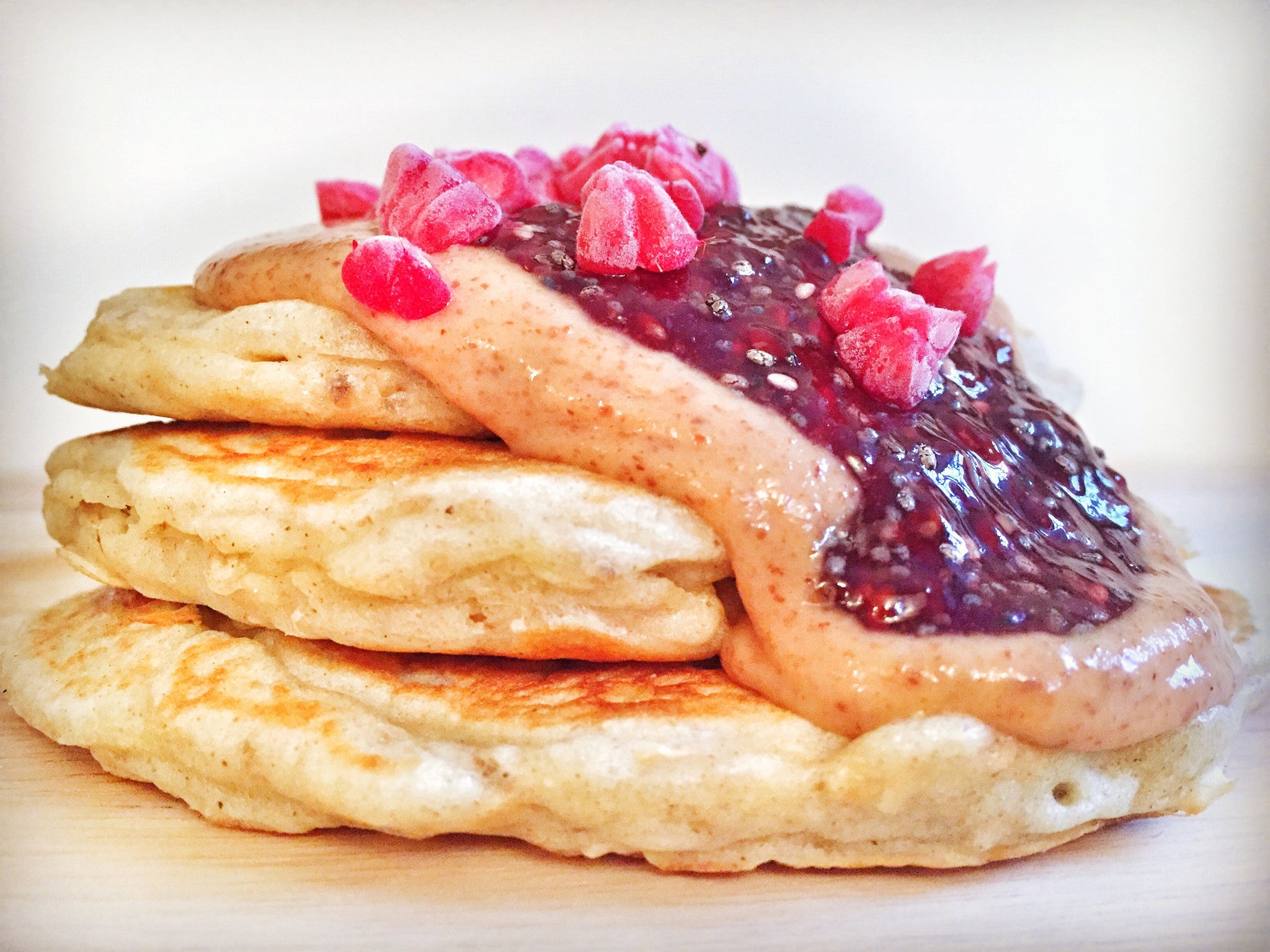 Oat pancakes with chia jam and nut butter drizzle